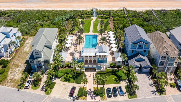 A beachfront property with a central pool, multiple guest houses, and a beach access walkway.