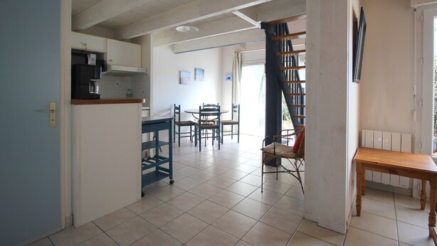 Una cocina amplia con comedor, una escalera y vistas al exterior.
