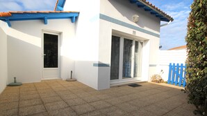 Un edificio con fachada blanca, puerta azul y cerca azul.