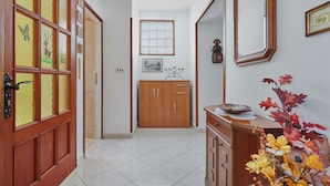 A hallway with a wooden door, a cabinet, and a mirror. - Nice family house for 2 to 4 people (Ližnjan)