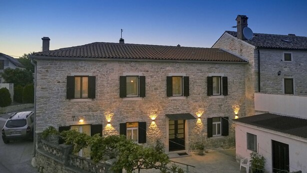 A stone building with multiple windows and a sign indicating directions to Pula/Pola and Sisan/Sissano. - Nice family house for 2 to 4 people (Ližnjan)