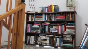 A staircase with a wooden railing leading to a room. A bookshelf filled with books is located at the top of the stairs. - LA LAJITA OCEAN VIEW 2 (La Lajita)