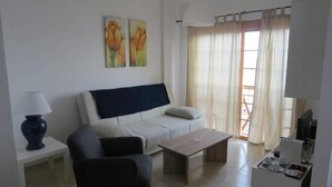 A living room with a sofa, two armchairs, a coffee table, a lamp, and a TV. - LA LAJITA OCEAN VIEW 2 (La Lajita)