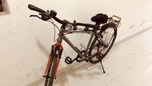 Un vélo avec un panier et une gourde, garé à l’intérieur.