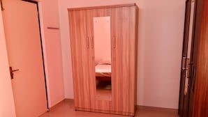 Une chambre à coucher avec un lit, une armoire et une porte.