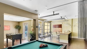 A pool table with balls, a foosball table, and a bar area with stools. - Airy SoCo 2BR King Suite w/ GymPickleballLaundry (Austin)