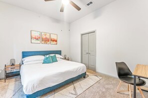 Un dormitorio con cama, escritorio, silla y armario.