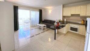 A modern apartment with a balcony, a dining area, and a kitchen. - Ocean Golf & Country Club A2 (Oasis del Sur)