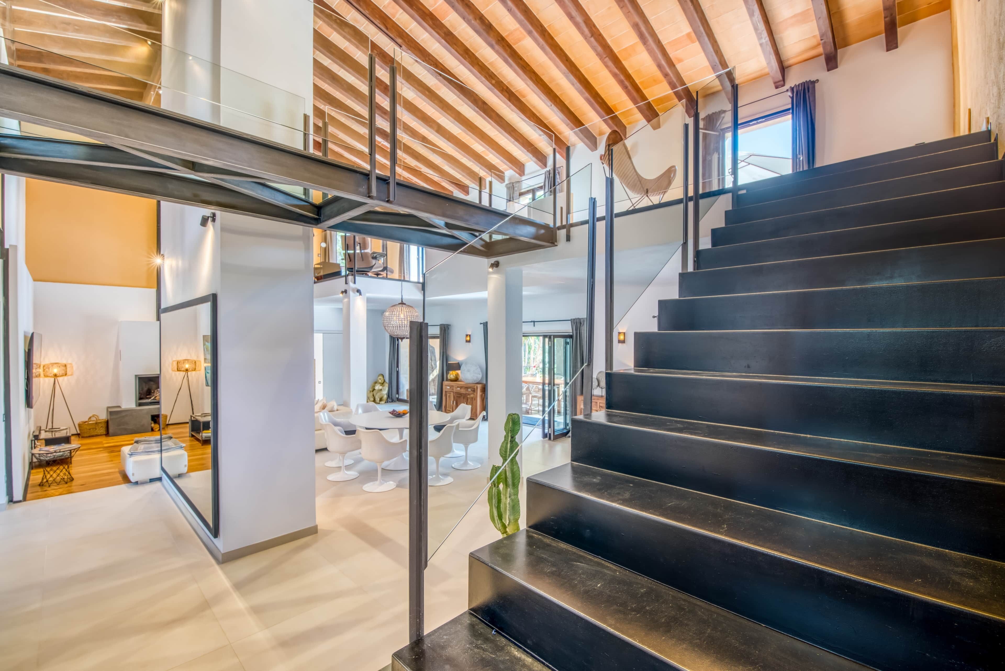A modern interior with a staircase, a dining area, and a living space.