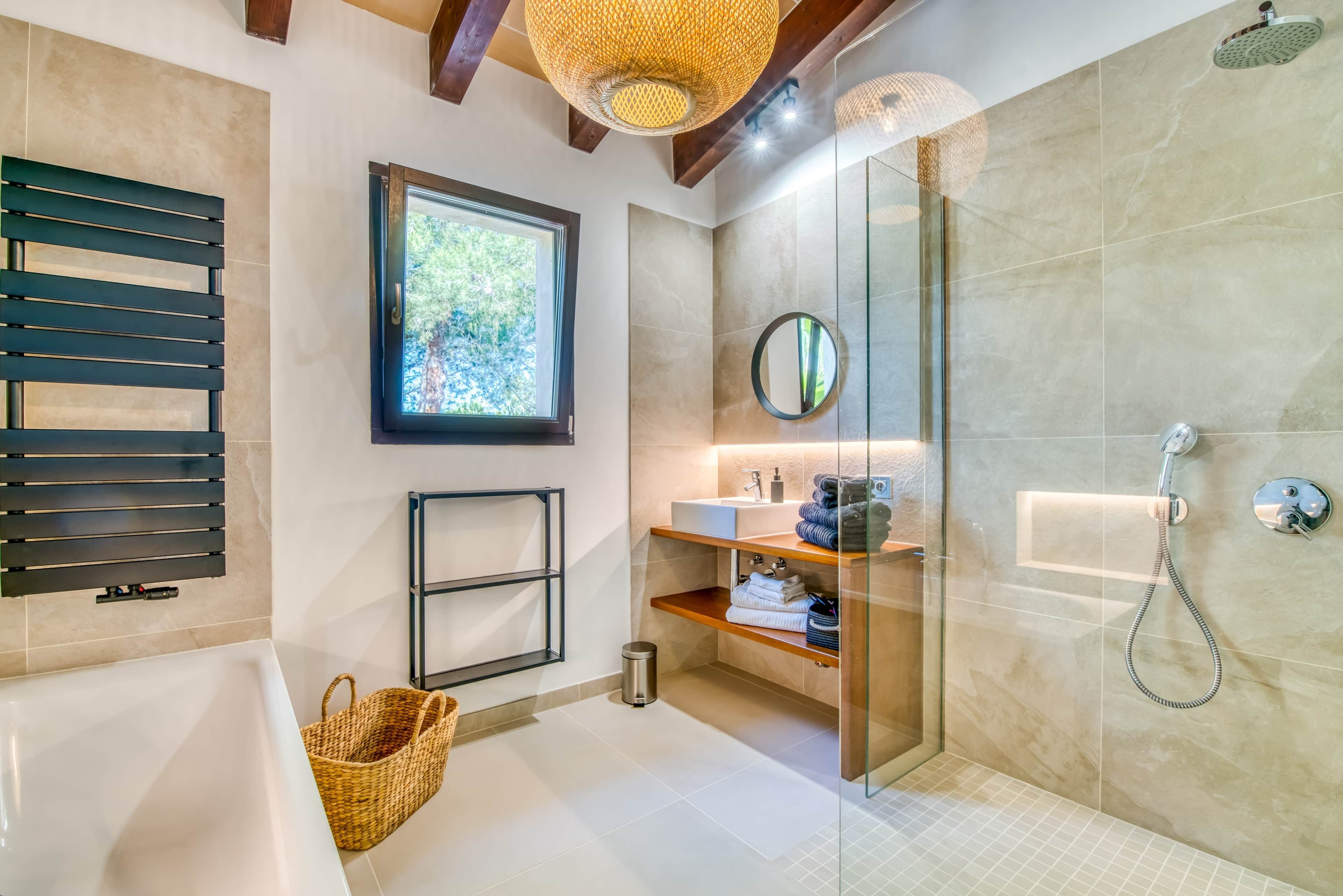 Ein modernes Badezimmer mit Badewanne, Duschkabine, Fenster und Holzregal mit Handtüchern.