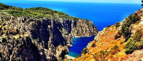 A rugged cliffside with a clear view of the sea.