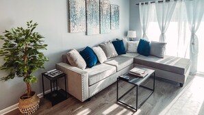 Un salon moderne avec un canapé, une table basse et un ventilateur de plafond.