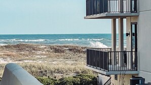 Un bâtiment moderne doté de nombreux balcons donnant sur une plage.