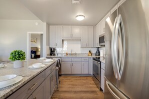 Enjoy cooking in this well-equipped kitchen with a central island, stainless steel appliances, and ample cabinetry.