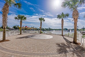 Stroll through the serene outdoor space surrounded by palm trees and a white fence.