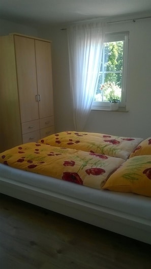 Une chambre à coucher avec un lit, une armoire et une fenêtre.