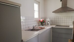 A kitchen with a sink, a coffee maker, and a window.