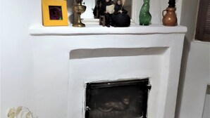 A white fireplace with a mirror above it, a yellow picture frame, a brass lamp, and decorative items on the mantel. - Village house 20 minutes from the beach (Piedicroce)