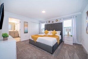 Cozy retreat with a large bed, nightstand, and dresser, offering a comfortable space to rest.