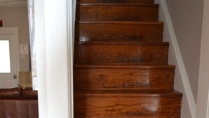 A wooden staircase with a handrail, leading to an upper floor. - 5 bed 2 Bath in Downtown Hermann, MO (Hermann)