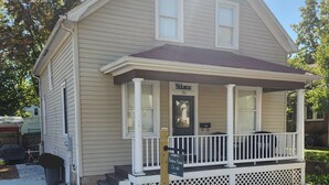 A two-story house with a front porch, a welcome sign, and a mailbox. - 5 bed 2 Bath in Downtown Hermann, MO (Hermann)