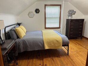 A bedroom with a bed, a dresser, a window with blinds, and a wall decoration. - House minutes from Pymatuning Lake! (Jamestown)