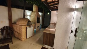 Uma cozinha com forno de tijolos, pia e móveis de madeira.