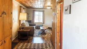 Ein Holzinterieur mit einer Couch, einem Tisch und einer Lampe.