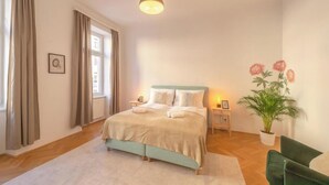 Une chambre à coucher avec un lit, une table de chevet, une plante en pot et une chaise.