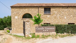 Un edificio de piedra con un cartel que dice 'Casale Ginisara'.