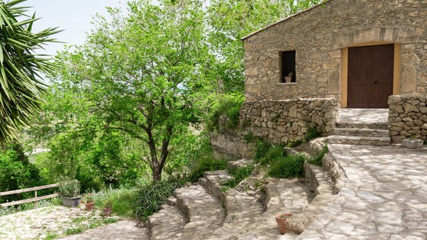Un edificio de piedra con una puerta de madera y una ventana pequeña.