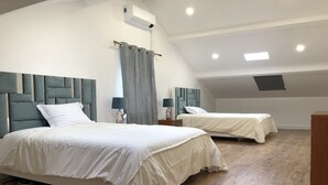 A bedroom with two beds, a ceiling fan, and a skylight. - Villa Pópulo 5 min. from the beach (ponta delgada)