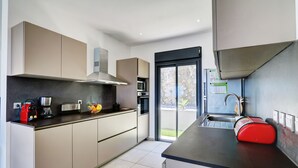 A modern kitchen with a built-in oven, microwave, and coffee maker.