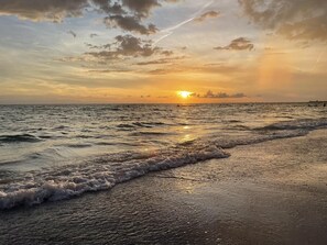 Una playa con olas al atardecer.