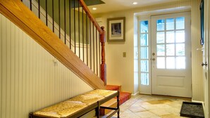 A staircase with a wooden handrail and a bench at the bottom. - Extraordinary Stratton Ski On/Ski Off Home (Stratton)