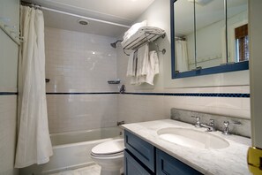 Un baño con bañera, inodoro y lavamanos.