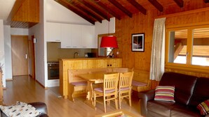 Un espacio de estar acogedor con una mesa de comedor de madera, sillas, un sofá de cuero y una mesita de centro.