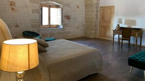 Een slaapkamer met een bed, een bureau, een stoel en een raam.