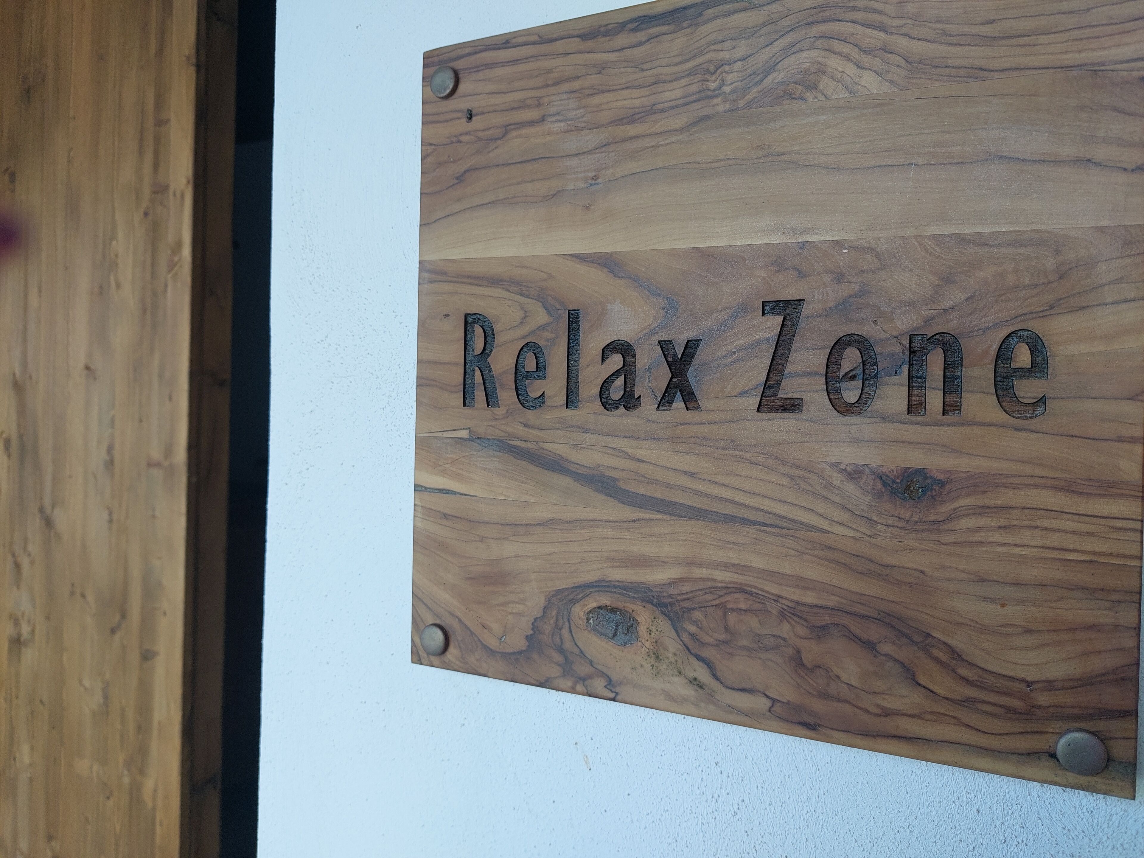 Ein hölzernes Schild mit der Aufschrift 'Relax Zone'.
