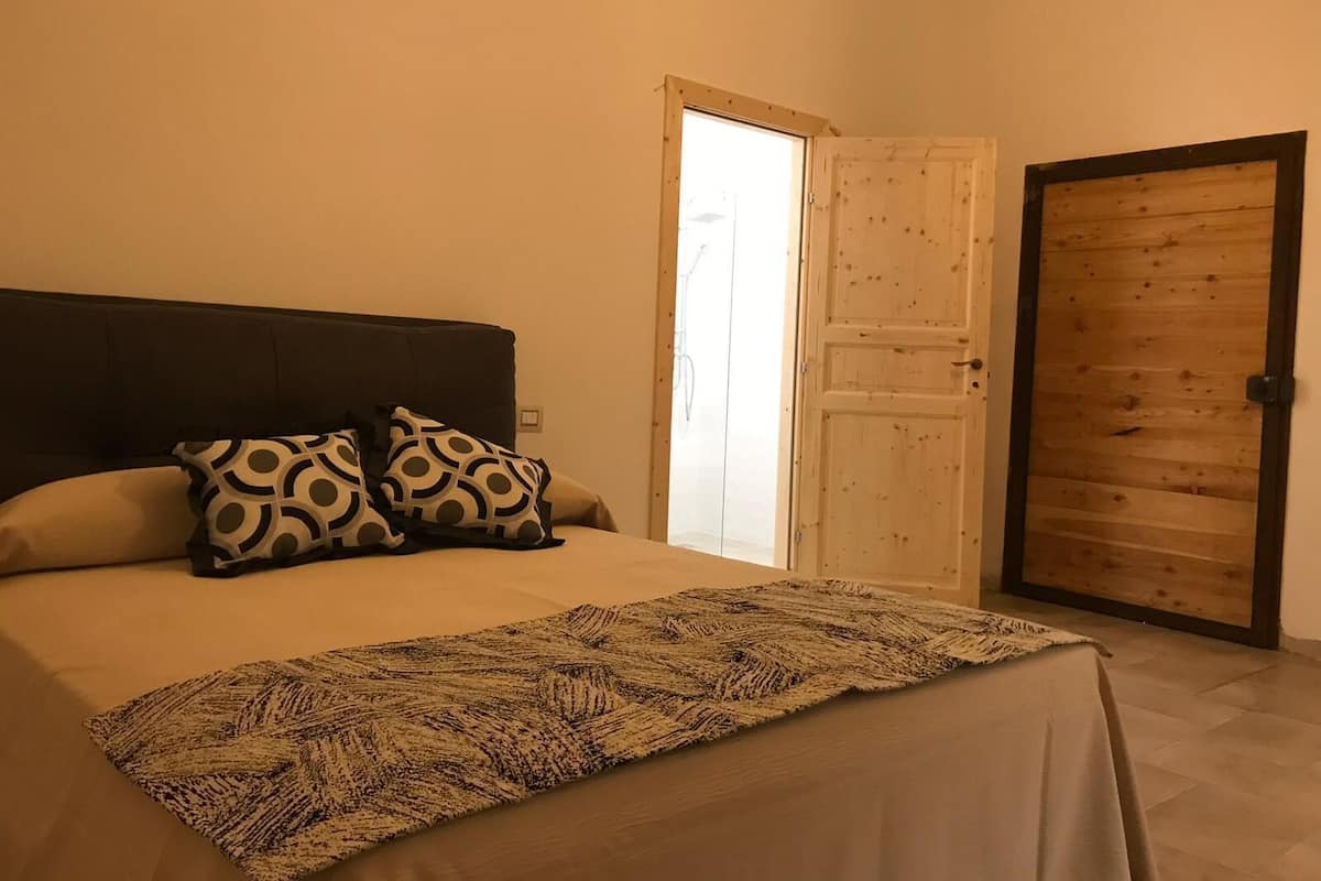 Ein Schlafzimmer mit Bett, Kissen und einer Tür.