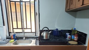 A kitchen with a sink, stove, and various kitchen items. - Cozy apartment minutes away from downtown, hiking trails, and beach attractions. (Freetown)