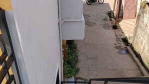 A staircase leading to a building entrance with a metal railing and a small window. - Cozy apartment minutes away from downtown, hiking trails, and beach attractions. (Freetown)