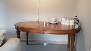A dining table with a hanging light, salt and pepper shakers, a coffee grinder, and labeled containers for tea, sugar, and creamer. - Cozy apartment minutes away from downtown, hiking trails, and beach attractions. (Freetown)