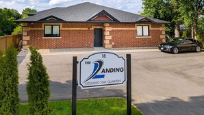 A brick building with a sign indicating 'The 2 ANDING Extended Stay Quarters'. - The Landing - Extended Stay Quarters (Meaford)