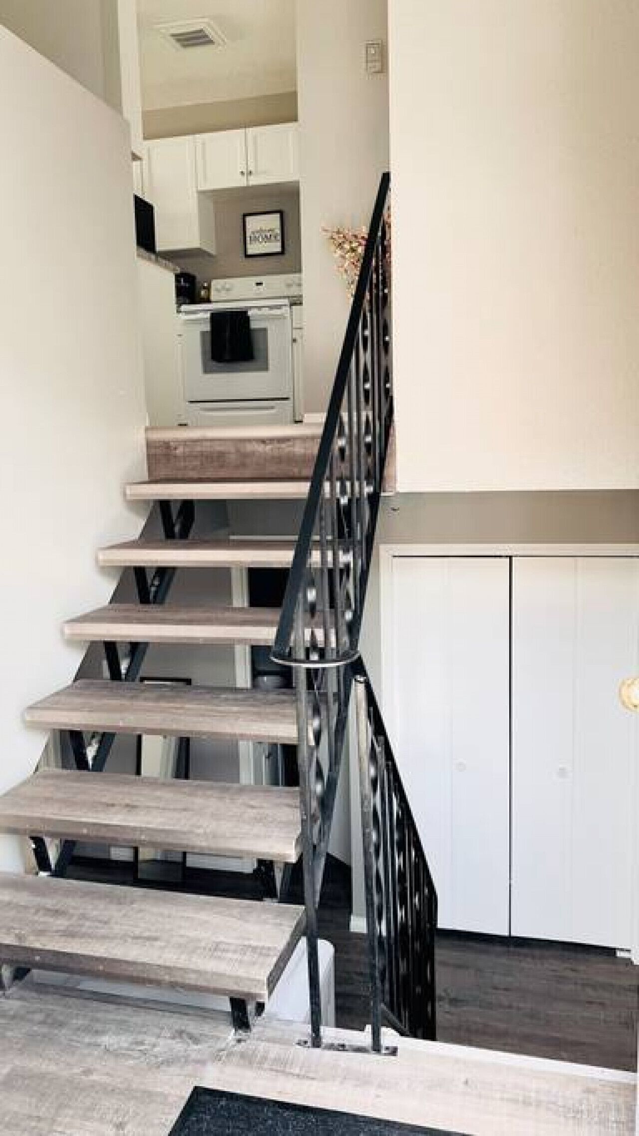 Un escalier avec une rampe métallique menant à l’étage supérieur.