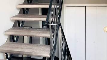 Un escalier avec une rampe métallique menant à l’étage supérieur.