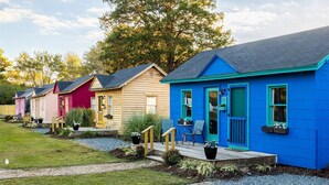 Una hilera de casas móviles coloridas, con un pequeño porche y macetas.