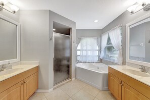 A modern bathroom with two sinks, a shower, and a bathtub. - Luxurious Heated Saltwater Pool Home (Cape Coral)