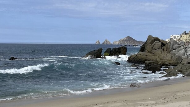 A beach with rocky outcrops and a clear view of the ocean. - Beautiful Ocean View Home (Cabo San Lucas)
