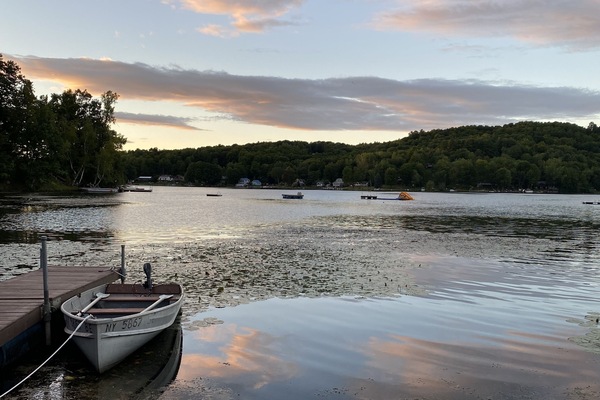 Dock, boat, and lakefront at sunset